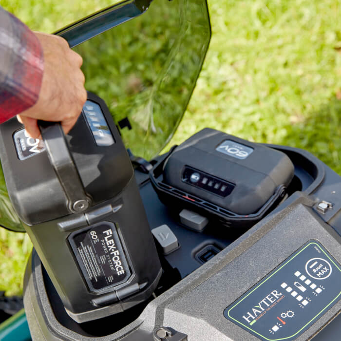 Toro 60V Flex-Force 8.0Ah battery being inserted into a Hayter cordless lawnmower