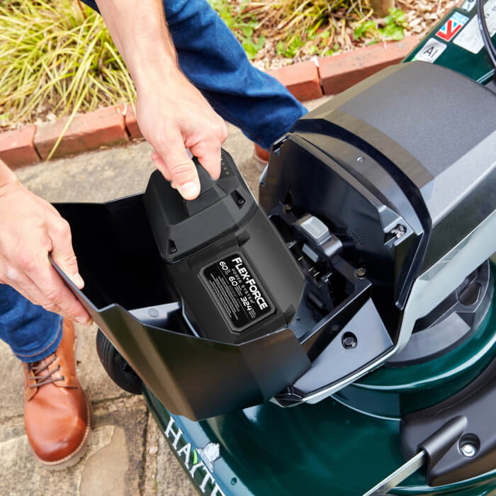 Toro 60V Flex-Force 6.0Ah battery being inserted into a Hayter cordless lawnmower